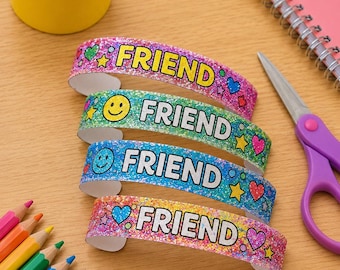 May include: Four glittery, curved wristbands featuring the word FRIEND in bold black letters. Each band displays colourful patterns including smiley faces, hearts, and stars in pink, green, blue, and orange hues with a sparkling texture.