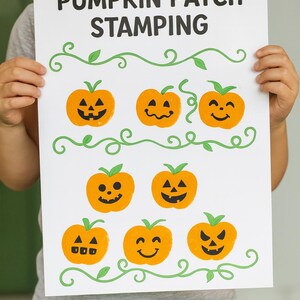 Puede incluir: Un papel blanco con el texto "PUMPKIN PATCH STAMPING" en negro. El papel presenta sellos de calabazas naranjas con varias caras talladas y vides verdes con hojas. El papel es sostenido por una persona.