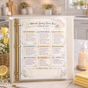 May include: A cream-colored binder with gold accents, open to a checklist titled "Ultimate Spring Home Reset." The checklist includes sections for various rooms, with checkboxes for tasks. A pen rests on the surface.