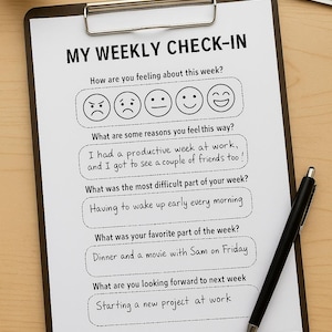 May include: A clipboard with a "MY WEEKLY CHECK-IN" form, a black pen, and a small plant. The form includes questions about the week's feelings and experiences, with a range of emoji faces for responses.