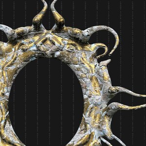May include: A gold and white ornate frame with a circular opening. The frame is made of a textured material that resembles stone or plaster. The frame is decorated with intricate details and has a distressed look.