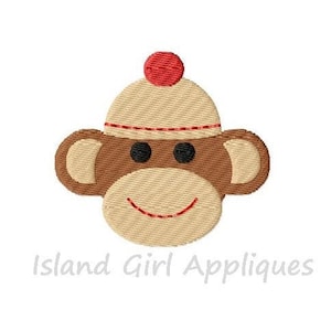 May include: Embroidered design of a monkey wearing a white knit hat with a red pom-pom. The monkey has brown fur and a smiling face.