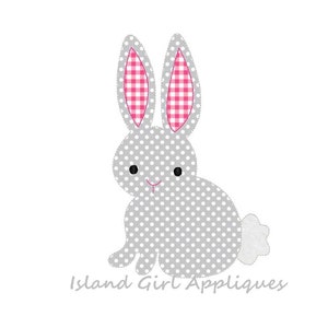 Könnte beinhalten: Ein graues Hasen-Applikationsmotiv mit weißen Punkten, rosa-weiß karierten Innenohren und einem flauschigen weißen Schwanz. Der Hase hat schwarze Augen und ein rosa gesticktes Lächeln. Der Text "Island Girl Appliques" steht unten.