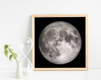 May include: A framed black and white photograph of a full moon against a dark background.