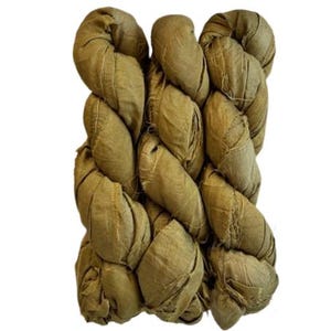 May include: Three skeins of olive green silk ribbon arranged side by side. The ribbon has a crinkled, textured appearance with visible frayed edges along the length of the fabric, creating a rustic and organic look for various craft projects.