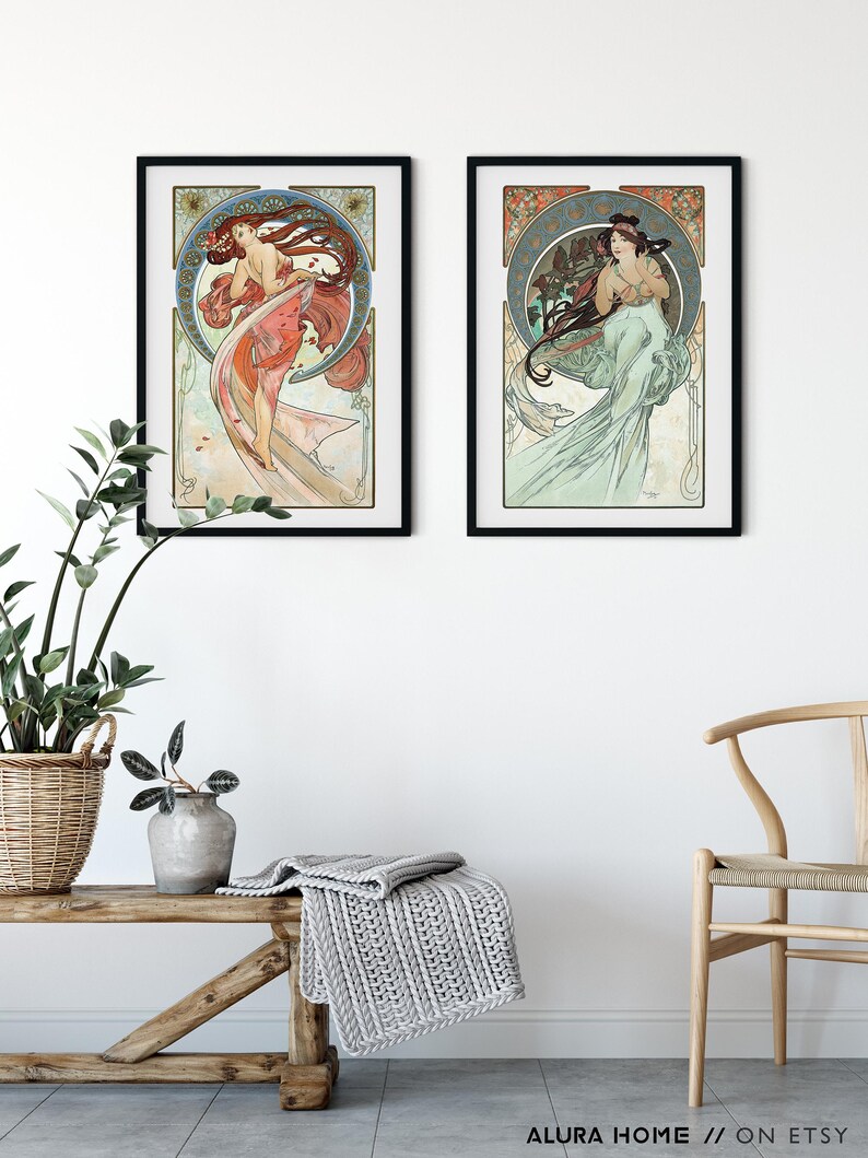 Puede incluir: Dos grabados enmarcados de estilo Art Nouveau que representan a mujeres elegantes con cabello y vestidos fluidos. La obra de arte tiene un dise&ntilde;o circular con elementos florales y decorativos. Los grabados est&aacute;n en marcos negros y cuelgan de una pared blanca.