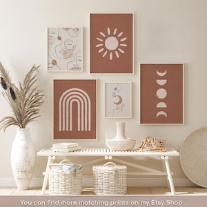 May include: A gallery wall set of five framed prints featuring terracotta and cream line art, including faces, a sun, a rainbow, hands with a moon, and moon phases. The text at the bottom reads: You can find more matching prints on my Etsy Shop.