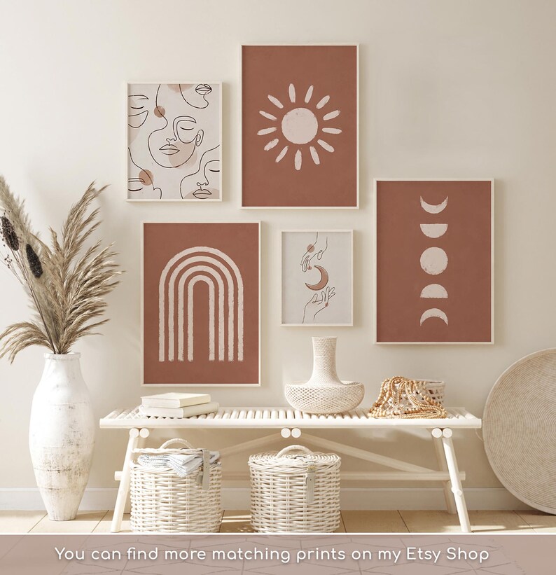 May include: A gallery wall set of five framed prints featuring terracotta and cream line art, including faces, a sun, a rainbow, hands with a moon, and moon phases. The text at the bottom reads: You can find more matching prints on my Etsy Shop.