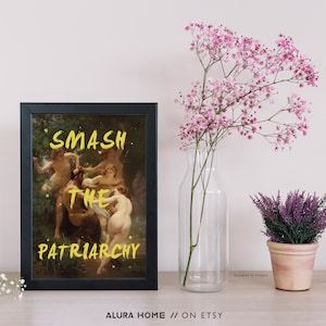 May include: A black framed print featuring a painting of a group of people in a woodland setting. The words "SMASH THE PATRIARCHY" are written in yellow over the painting.