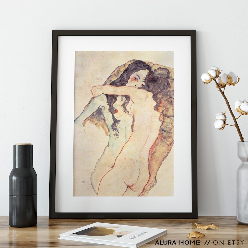 May include: Framed print of an abstract artwork featuring two figures embracing. The artwork is rendered in muted tones of beige, brown, and red, with a focus on the human form. The print is displayed in a black frame, adding a touch of elegance.