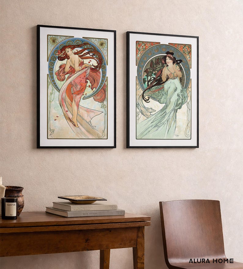 Puede incluir: Dos impresiones art&iacute;sticas enmarcadas con ilustraciones de estilo Art Nouveau de mujeres con cabello y prendas fluidas. La obra de arte tiene una paleta de colores suaves con detalles en rojo, naranja y verde, sobre un fondo crema.