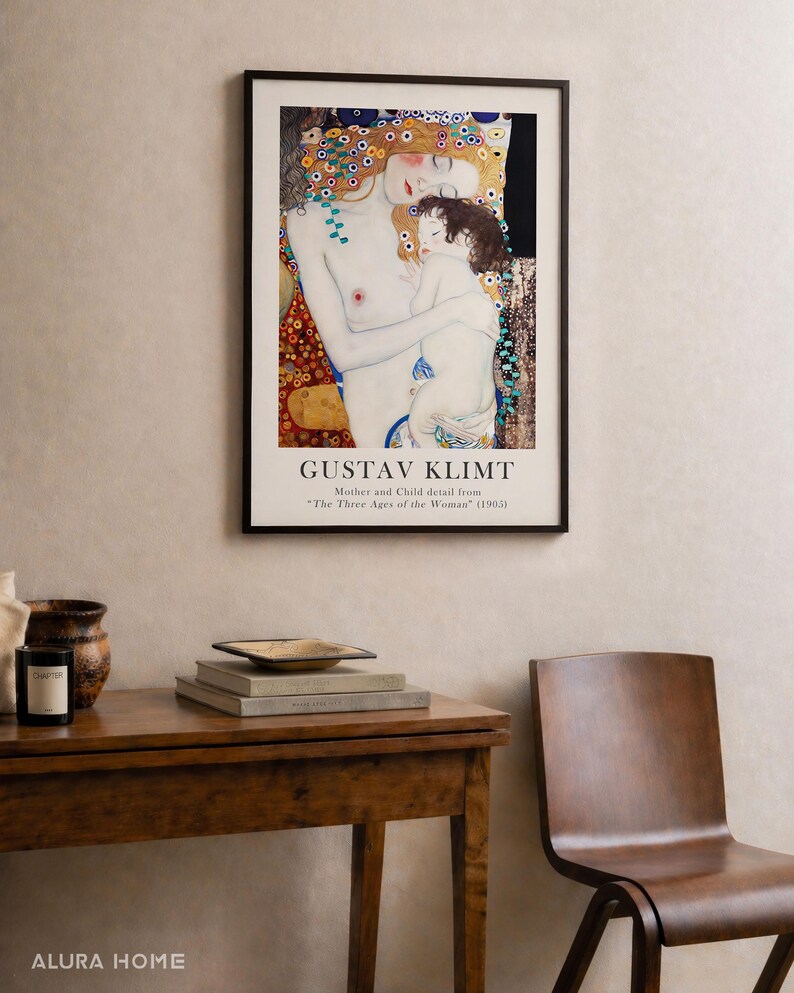 May include: A framed art print featuring Gustav Klimt's Mother and Child detail from The Three Ages of the Woman (1905). The artwork displays a pale figure embracing a child, surrounded by decorative gold, blue, and red patterns on a black background.