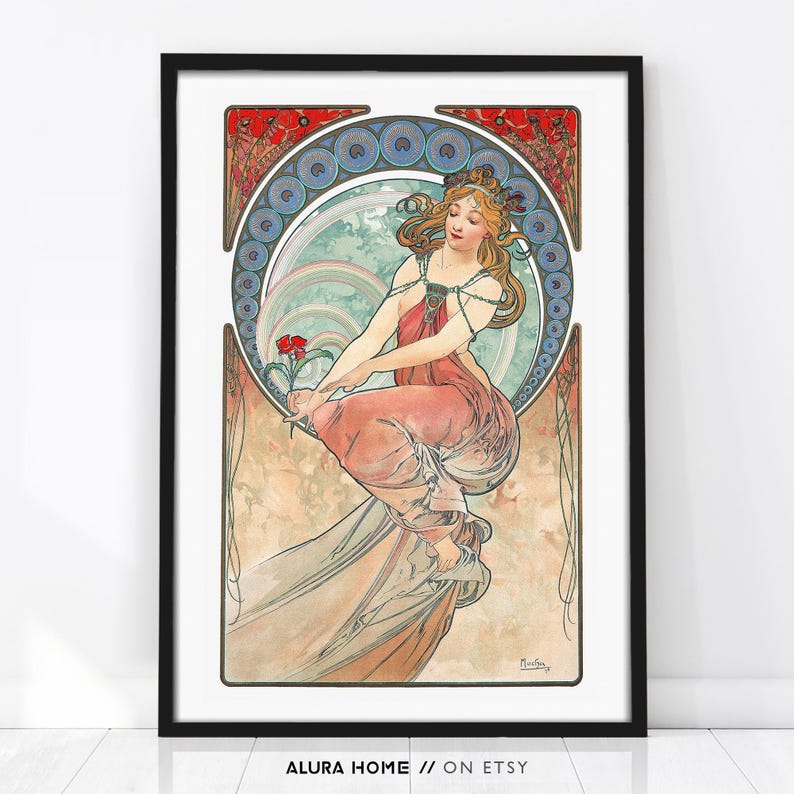 Puede incluir: Una l&aacute;mina art&iacute;stica enmarcada que muestra la ilustraci&oacute;n de una persona con cabello suelto y una prenda rosa drapeada, sosteniendo una flor roja. El dise&ntilde;o incluye un borde circular azul y blanco con detalles florales rojos y la firma Mucha.