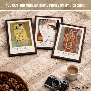 May include: Three framed art prints featuring Gustav Klimt paintings titled The Kiss, The Three Ages of Woman, and Hygieia. Each print is housed in a dark brown frame with white matting and black text identifying the artist and the artwork title.