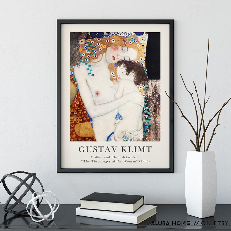 May include: A framed art print featuring Gustav Klimt's Mother and Child detail from The Three Ages of the Woman (1905). The artwork displays a pale woman with long reddish hair holding a small child, surrounded by decorative gold and floral patterns.