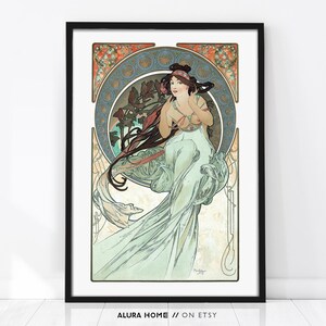 Puede incluir: Una impresi&oacute;n art&iacute;stica enmarcada que presenta a una mujer con un vestido fluido, cabello largo y oscuro y una diadema floral. La obra de arte tiene un estilo vintage con un dise&ntilde;o circular en el fondo, y la paleta de colores incluye verdes, azules y rojos suaves. El texto "ALURA HOME // ON ETSY" est&aacute; en la parte inferior.