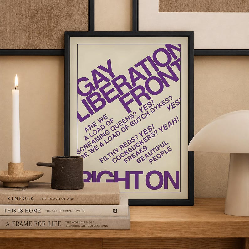 May include: A rectangular black-framed wall art print featuring bold purple text on a cream background. The text reads GAY LIBERATION FRONT, ARE WE A LOAD OF SCREAMING QUEENS? YES! ARE WE A LOAD OF BUTCH DYKES? YES! FILTHY REDS? YES! COCKSUCKERS? YEAH! FREAKS BEAUTIFUL PEOPLE RIGHT ON.