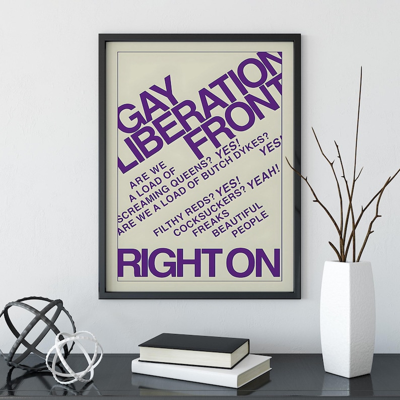 May include: A framed poster with a cream background and bold purple text that reads GAY LIBERATION FRONT, ARE WE A LOAD OF SCREAMING QUEENS? YES! ARE WE A LOAD OF BUTCH DYKES? YES! FILTHY REDS? YES! COCKSUCKERS? YEAH! FREAKS BEAUTIFUL PEOPLE RIGHT ON.
