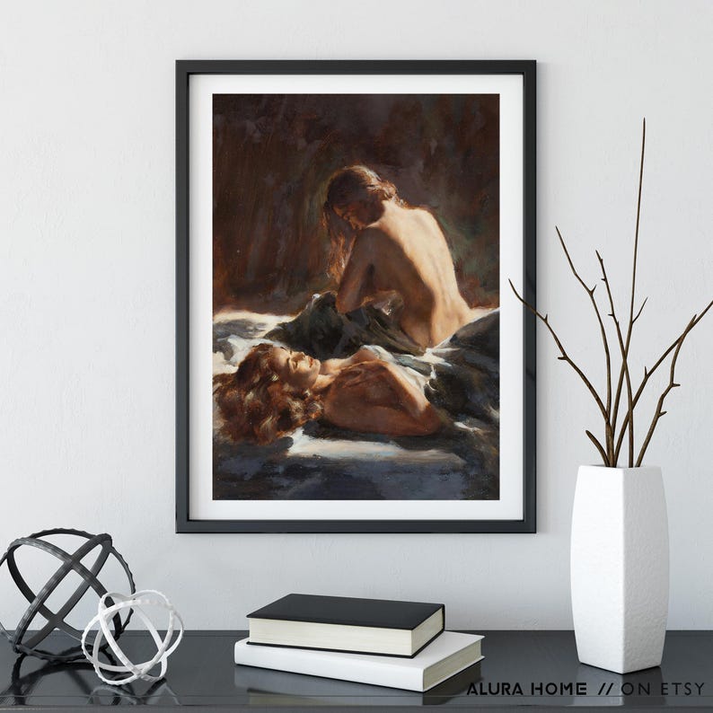 Pode incluir: Uma impress&atilde;o emoldurada de uma pintura a &oacute;leo que retrata duas figuras em um abra&ccedil;o terno. A obra de arte apresenta tons quentes, com uma figura reclinada e a outra sentada, criando uma sensa&ccedil;&atilde;o de intimidade e emo&ccedil;&atilde;o. A moldura &eacute; preta.