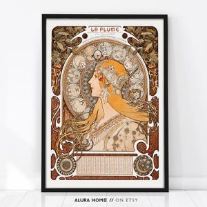 Puede incluir: Una l&aacute;mina enmarcada titulada LA PLUME que muestra la ilustraci&oacute;n de perfil de una persona con el pelo largo y suelto, con un tocado ornamentado. El fondo muestra un calendario zodiacal circular con doce s&iacute;mbolos, rodeado de intrincados patrones de follaje marr&oacute;n y dorado.