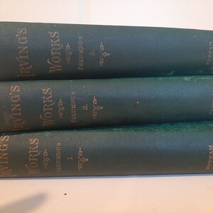 May include: Three green hardcover books stacked on top of each other. The books are titled "Irving's Works" and each book has a different volume number. The books are part of the Putnam's Edition.