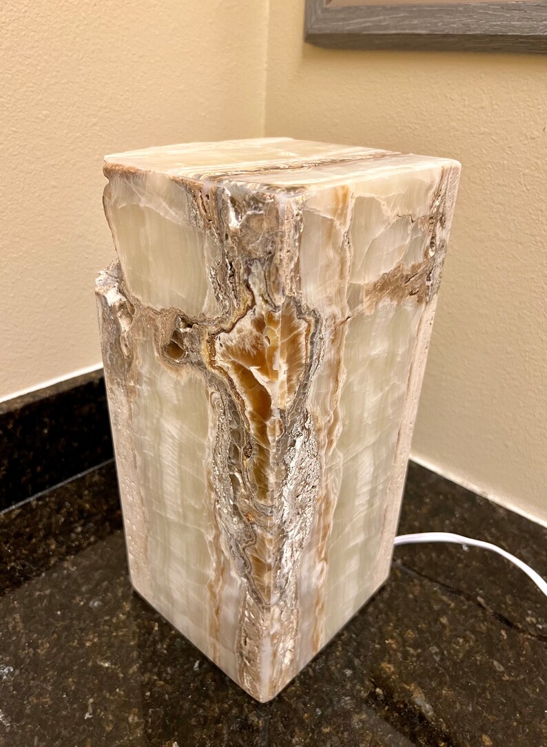 May include: A white and brown onyx lamp base with a natural, textured finish. The base is square and has a modern design.