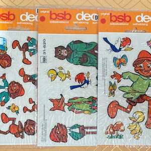 Könnte beinhalten: Drei Bögen mit bunten, selbstklebenden Aufklebern mit Comicfiguren. Die Aufkleber sind von der deutschen Marke "bsb decor" und mit den Nummern "31-620" und "31-315" gekennzeichnet.