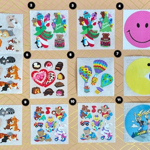 Op de afbeelding: Een vel met stickers met verschillende ontwerpen, waaronder katten, kerstboom, harten, luchtballonnen, een Pac-Man-personage en cartoonfiguren. De stickers zijn op een roze en witte gepatroneerde achtergrond.