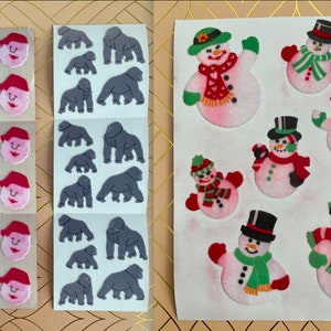 May include: Two sheets of stickers. One sheet has 12 stickers of Father Christmas with a red hat and white beard. The other sheet has 12 stickers of gorillas in various poses.