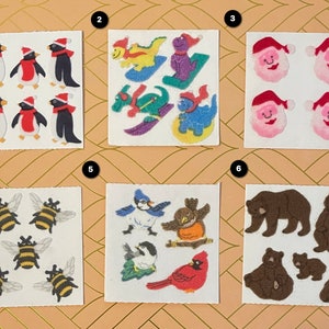 以下が含まれることがあります： 冬と動物をテーマにしたステッカーが6枚セットになっています。最初のシートには、赤、白、黒のペンギンが6羽描かれています。2枚目のシートには、カラフルな恐竜が4匹描かれています。3枚目のシートには、サンタクロースの顔が4つ描かれています。4枚目のシートには、ミツバチが4匹描かれています。5枚目のシートには、青い鳥、コマドリ、シジュウカラ、そして赤い鳥など、鳥が4羽描かれています。6枚目のシートには、茶色のクマが4匹描かれています。