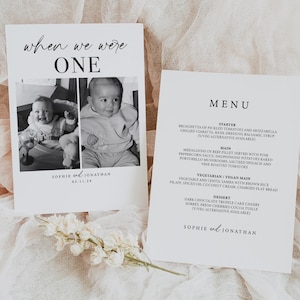 May include: A black and white photo of a baby on a white card with the text "when we were one" and "Sophie and Jonathan 03.11.24". The card is next to a white menu card with the text "MENU" and a list of food items.