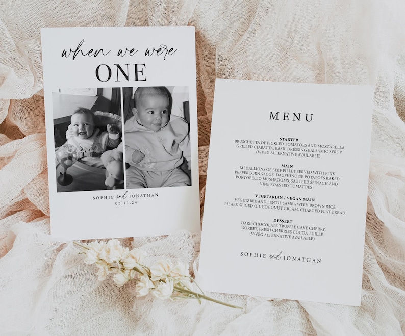 May include: A black and white photo of a baby on a white card with the text "when we were one" and "Sophie and Jonathan 03.11.24". The card is next to a white menu card with the text "MENU" and a list of food items.