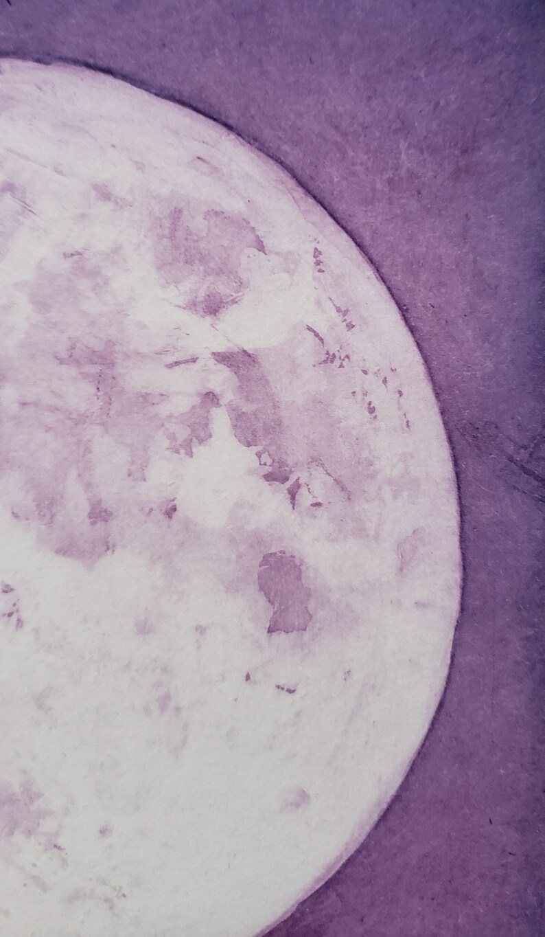 May include: A close-up of a watercolor painting of a purple moon. The moon is painted in shades of purple and white, with a textured surface.
