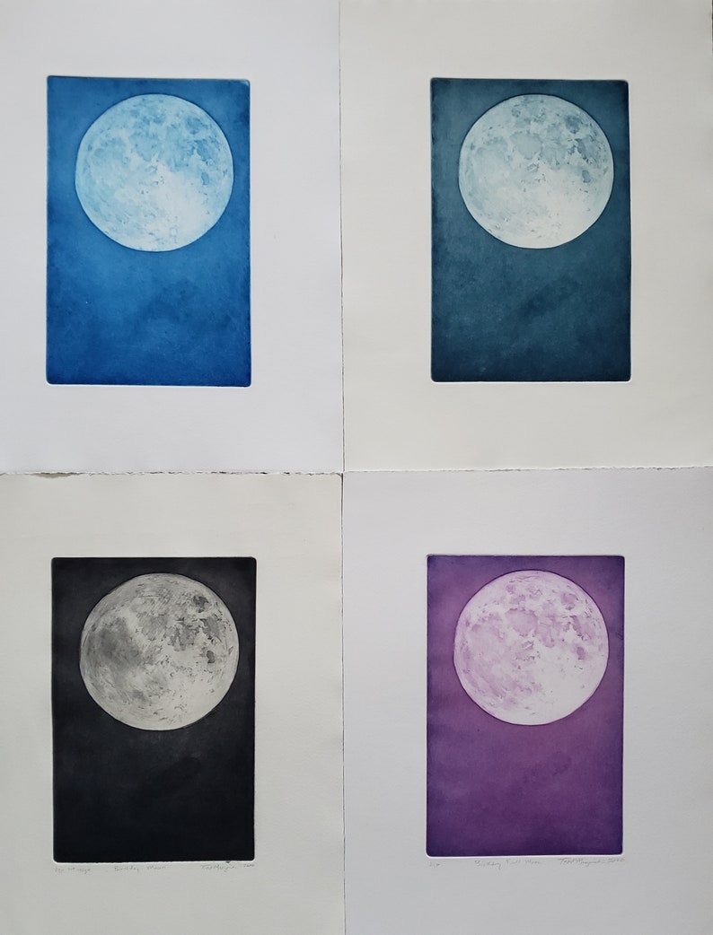 May include: Four different colored prints of the full moon. Each print is framed in a white mat and has a white border. The moon is depicted in shades of blue, teal, gray, and purple.