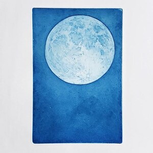 May include: A blue and white print of a full moon against a dark blue background.