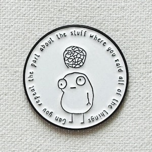 Peut inclure: Une épingle en émail blanc avec un contour noir d'un personnage de dessin animé avec une bulle de pensée au-dessus de sa tête. Le texte autour du personnage dit "Can you separate the part about the stuff where you said all of the things".