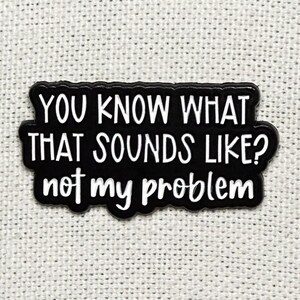 Pode incluir: Adesivo retangular preto com texto branco: "YOU KNOW WHAT THAT SOUNDS LIKE? not my problem". Fundo branco texturizado.