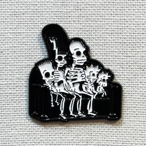 Pode incluir: Pin de esmalte preto e branco com um grupo de esqueletos sentados em um sofá. Os esqueletos estão vestidos e têm diferentes expressões faciais.