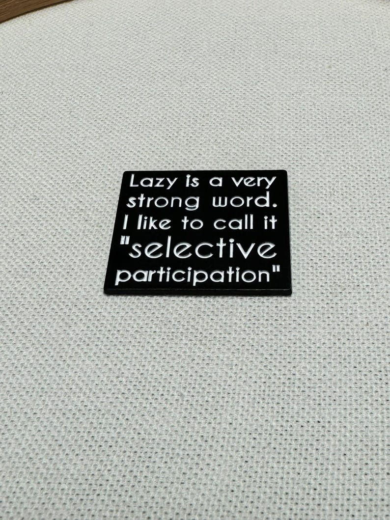 May include: Black square sign with white text that reads "Lazy is a very strong word. I like to call it "selective participation""