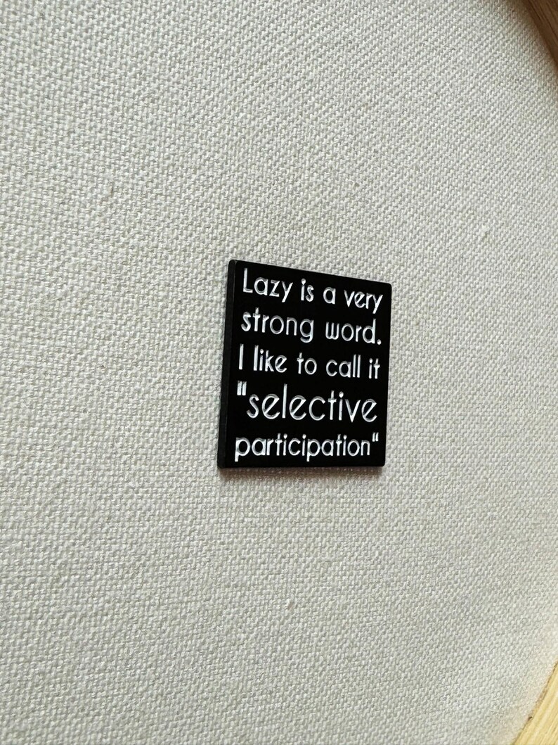May include: Black square sign with white text that reads "Lazy is a very strong word. I like to call it "selective participation""