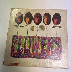 May include: A square vinyl record jacket titled FLOWERS featuring five oval portraits of men arranged like flowers on stems. The background is off-white with a colorful, intricate psychedelic pattern behind the text. The London logo is in the corner.