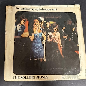 Może przedstawiać: Vintage okładka albumu The Rolling Stones, przedstawiająca grupę ludzi w słabo oświetlonym otoczeniu. Okładka zawiera tekst "You can't always get what you want" i nazwę zespołu. Obraz jest lekko zużyty.
