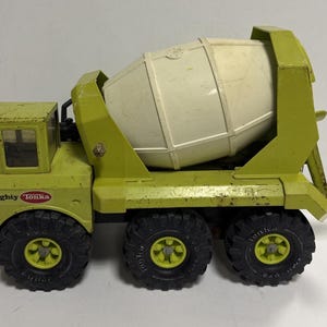 May include: Vintage Mighty Tonka cement mixer toy in shades of green and cream. The toy truck features a rotating drum, three axles with black tires, and the "Mighty Tonka" logo on the side.
