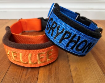 May include: Two personalized dog collars. One is orange with "KELLEE" embroidered in gold, and the other is blue with "GRYPHON" embroidered in black. Both collars have black buckles and brown or black trim.