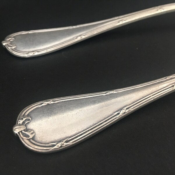 Christofle, Deux cuillères de table en métal argenté, Modèle à rubans croisés de style Louis XVI / Two silver-plated table spoons