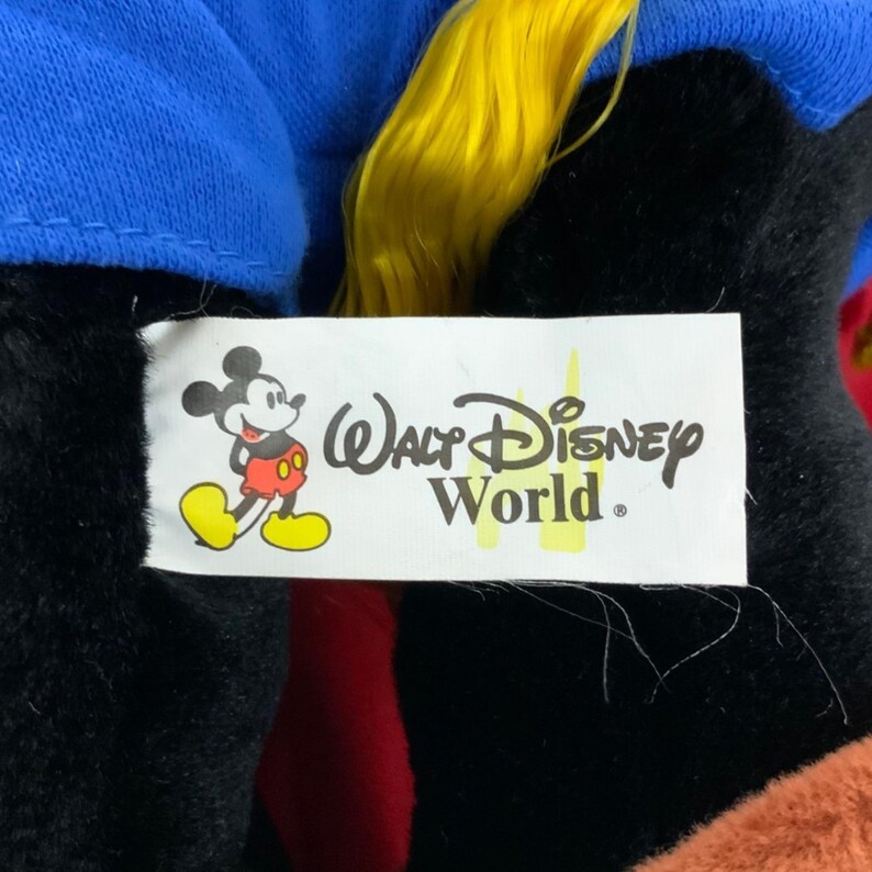Peut inclure: Peluche Mickey Mouse noire et bleue avec des cheveux jaunes. Le jouet a une &eacute;tiquette blanche attach&eacute;e &agrave; lui qui dit "Walt Disney World".