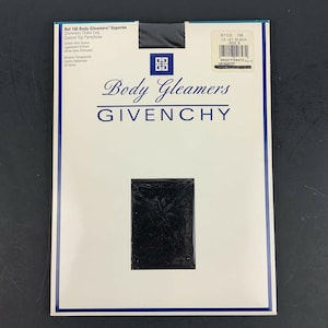 May include: A packet of Givenchy Body Gleamers control top pantyhose in Le Jet Black. The white packaging has blue trim and the brand name. The pantyhose are visible through a rectangular window. The size is B.