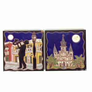 May include: Two ceramic tile coasters with a New Orleans theme. The first coaster features a silhouette of a musician playing a trumpet in front of a building with a street lamp. The second coaster features a church with palm trees in front of it. Both coasters have a blue background with a full moon.