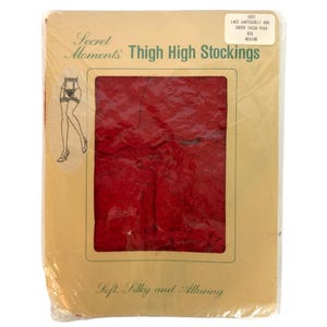 May include: A package of Secret Moments red thigh high stockings in medium size. The tan cardboard packaging features a graphic of a garter belt and stockings, with text reading 1032 LACE GARTERBELT AND SHEER THIGH HIGH RED MEDIUM.