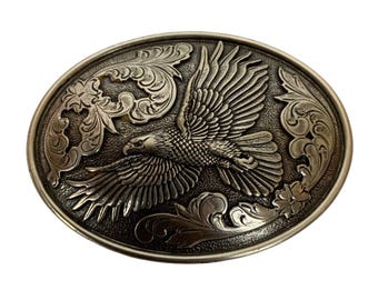 Hebilla de cinturón ovalada estilo western Nocona con diseño detallado de águila y flores, metal plateado.